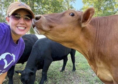 A volunteer enjoying a quiet moment interacting with a cow in the pasture