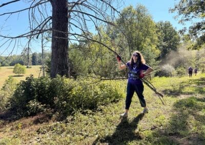 Volunteers lifting and carrying large tree branches out of the rehabilitation field