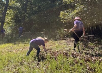 UVA volunteers working together to clear heavy logs and brush from the field